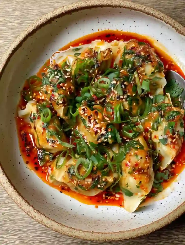 Overhead view of chili oil dumpling bake with sesame and scallions