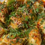 Close-up of dumpling bake in chili oil with sesame and herbs